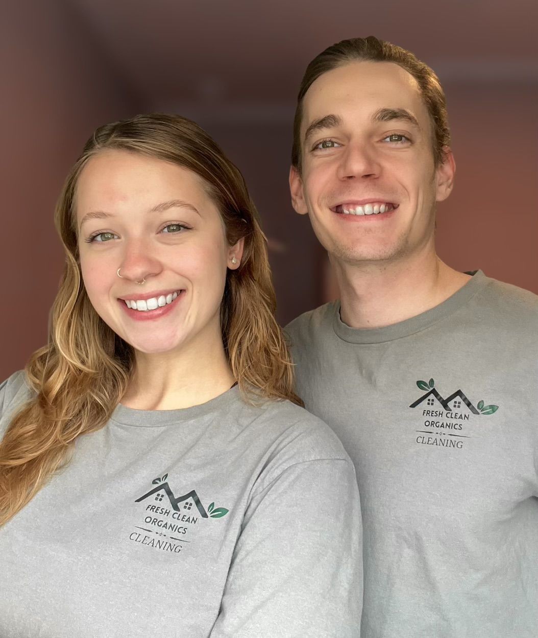 Two people smiling, wearing shirts with 'Fresh Clean Organics Cleaning' logo.